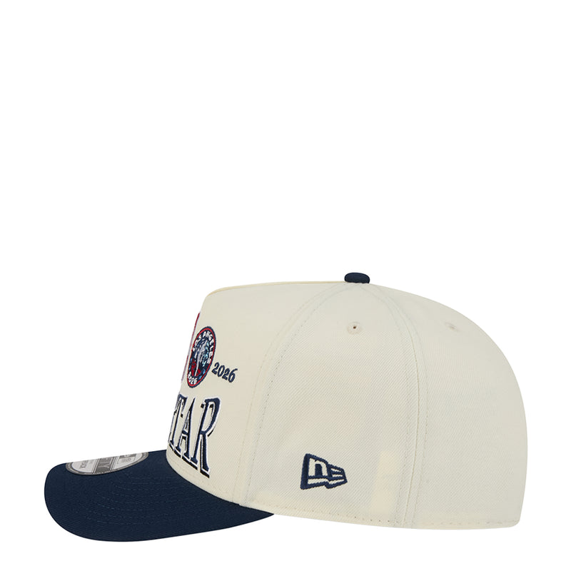 Cream baseball cap with navy brim, circular 2026 patch and New Era flag on back.