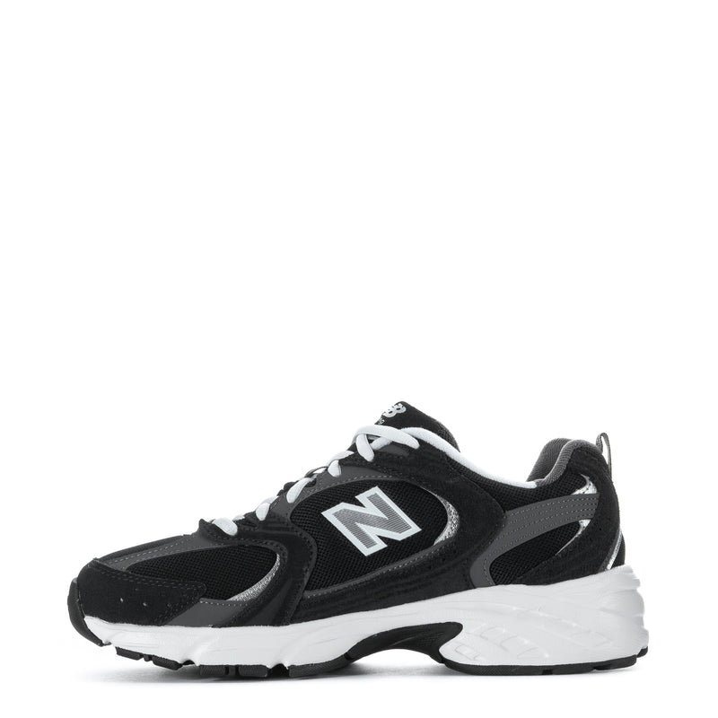 Wide women’s athletic sneakers, side view in black with white sole and N emblem
