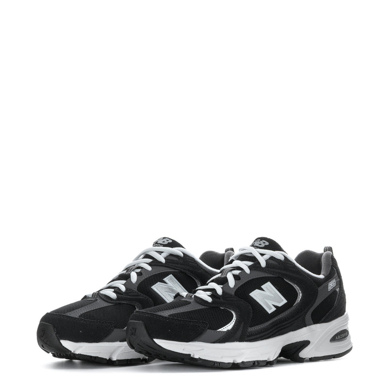 Wide women’s athletic sneakers, close front view with black uppers, white laces, N logo
