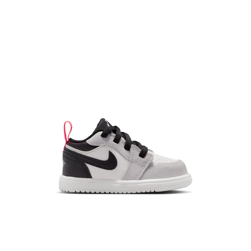 Kids low-top sneakers in white and black with black laces and red accents