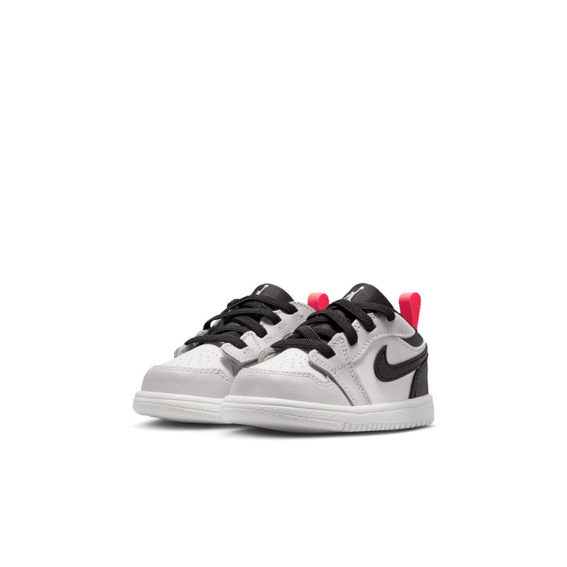 Kids low-top sneakers, white leather with black overlays, black laces, red heel accents