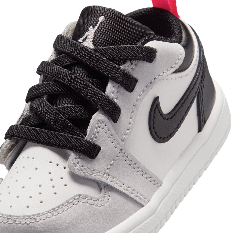 Kids low-top sneaker toe and lace-up with white panels, black laces, red lining detail