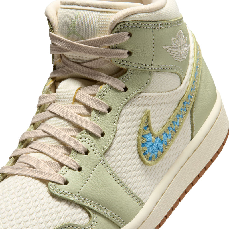 Close-up of women’s mid-top sneaker upper in light olive and white with blue swoosh