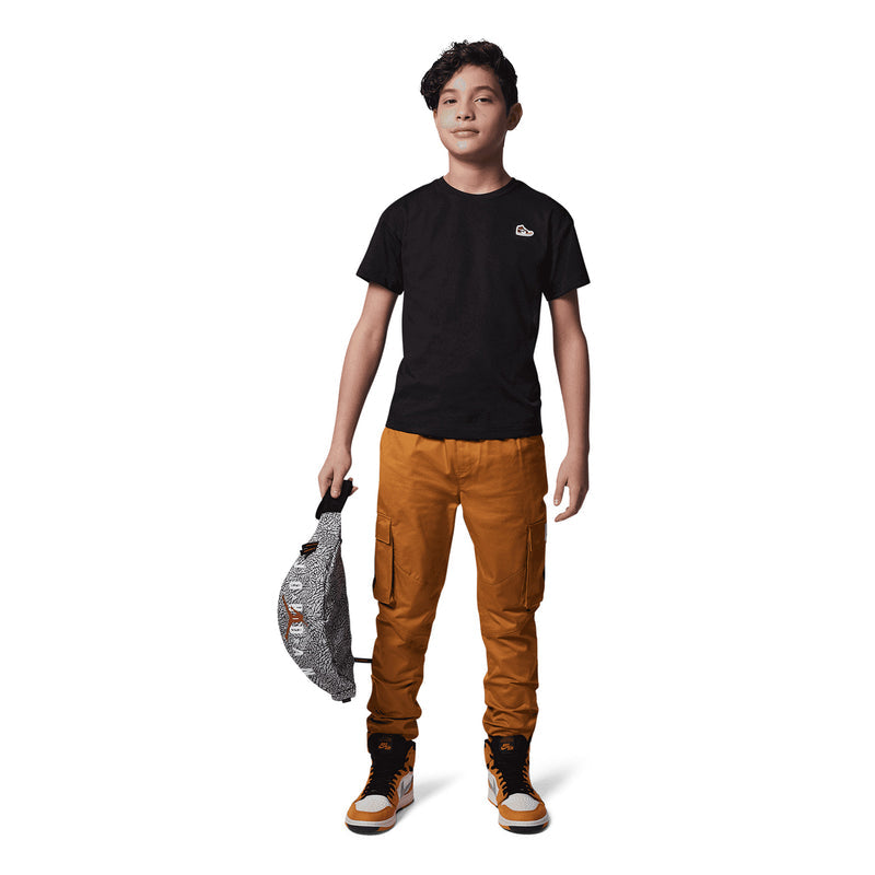 Black youth crewneck t-shirt worn with pants, sneaker logo patch on left chest