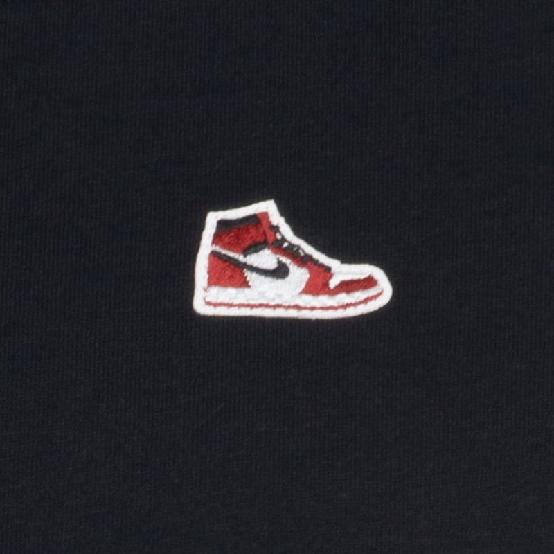 Embroidered sneaker logo patch on black youth t-shirt