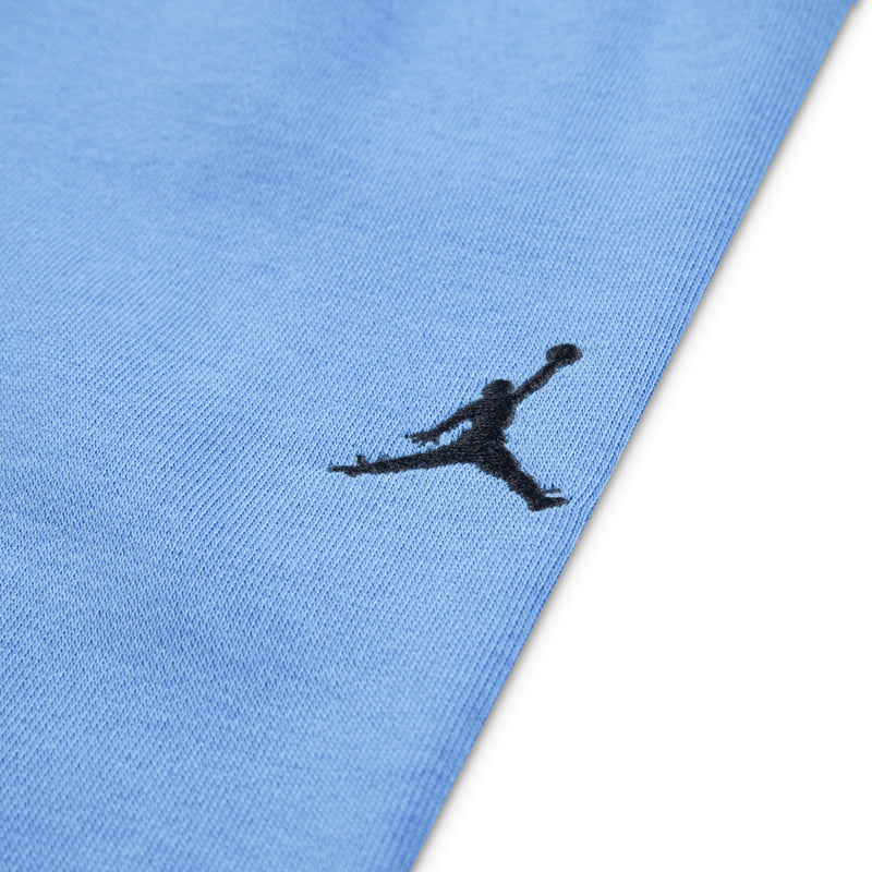 University blue fleece jogger fabric with black Jordan logo near hem