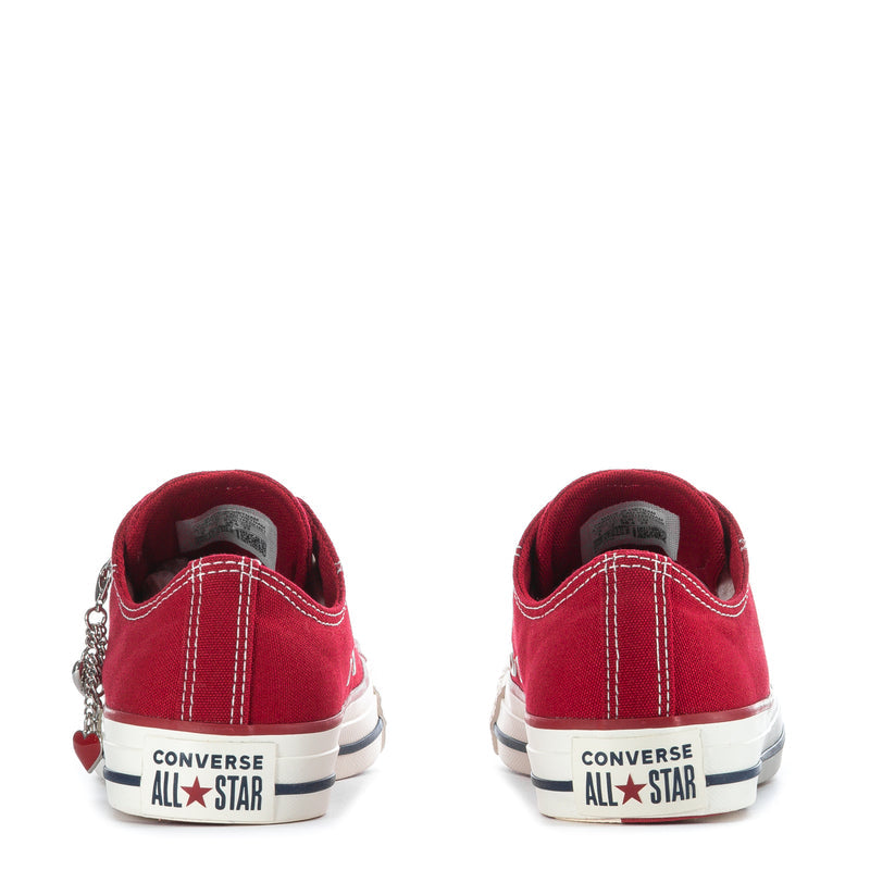 Womens red low-top sneaker backs with CONVERSE ALL STAR logo and dangling heart charm