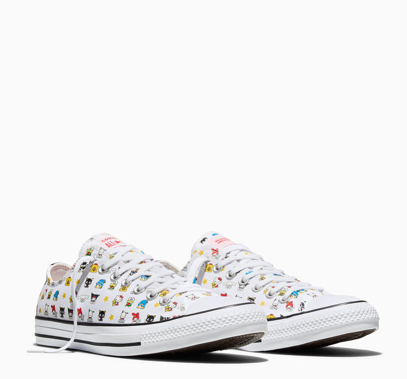 Pair of white youth low-top sneakers with multicolor character print and textured rubber toe caps