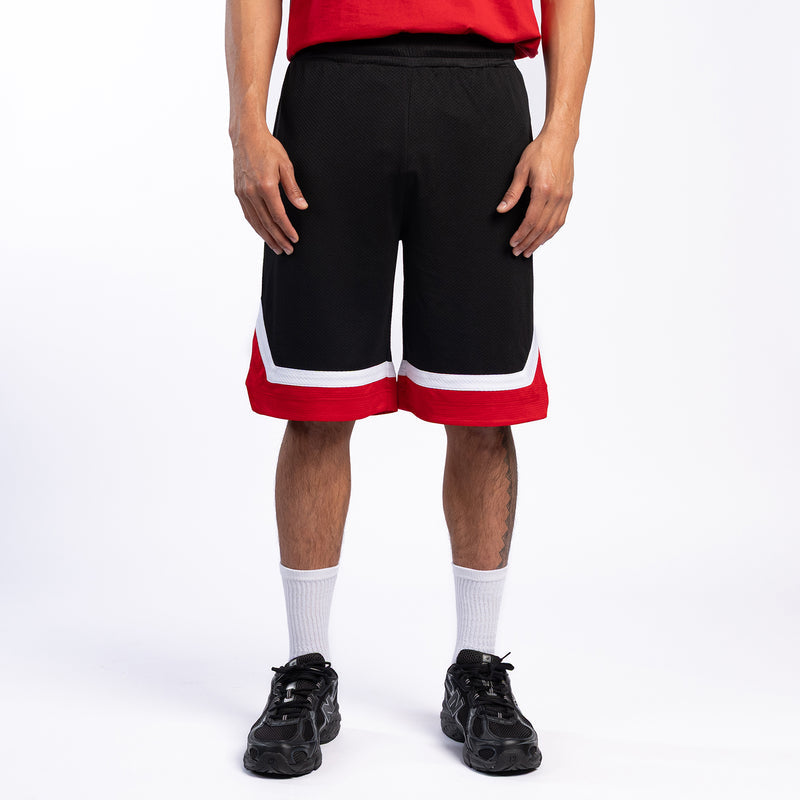 Black basketball shorts with red-and-white hem stripe, breathable mesh, back view