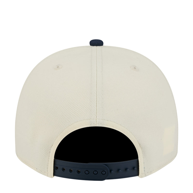 Two-tone A-frame cap back view, cream crown with adjustable navy strap holes