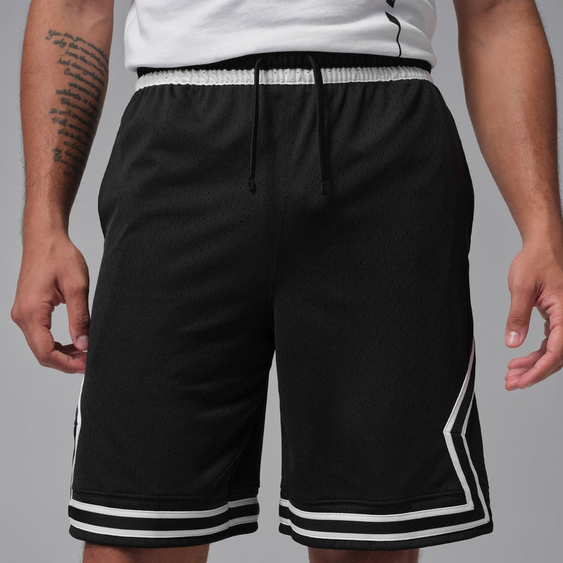 Men's black basketball shorts close-up with elastic waistband and white piping