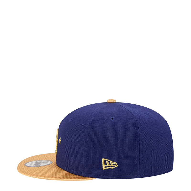 Navy baseball cap with gold New Era logo on side and tan brim