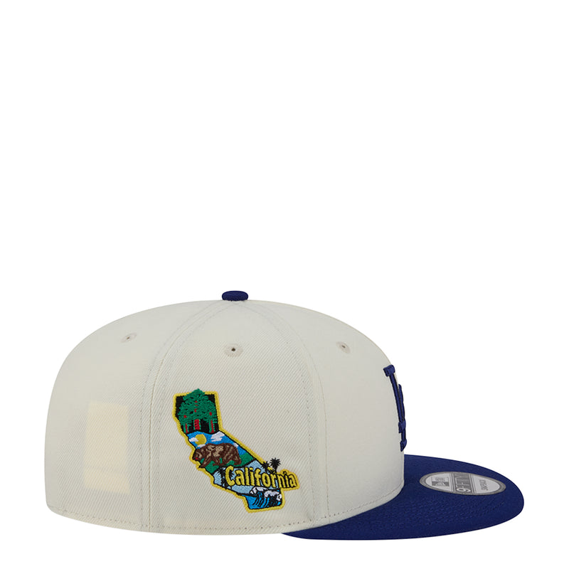 Two-tone baseball cap with cream crown and royal blue brim, with California patch.