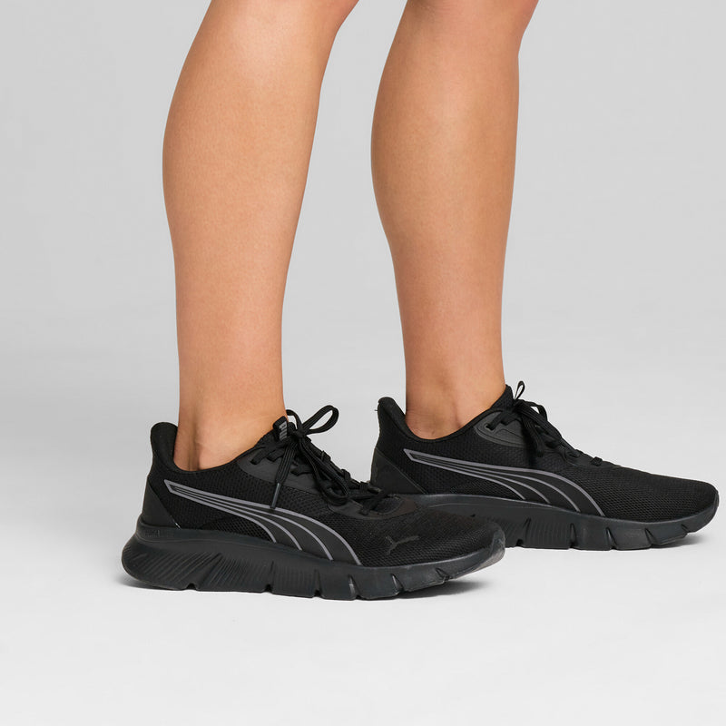 Black lace-up running shoes on legs, with gray side stripe and textured outsole.