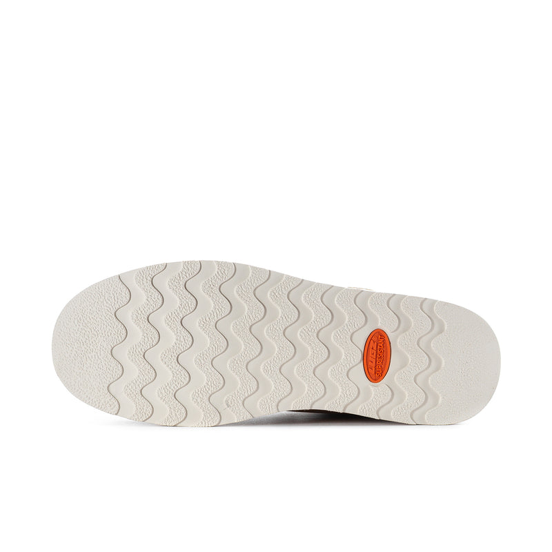 Men's tan chukka boot outsole with wavy tread pattern and orange logo detail