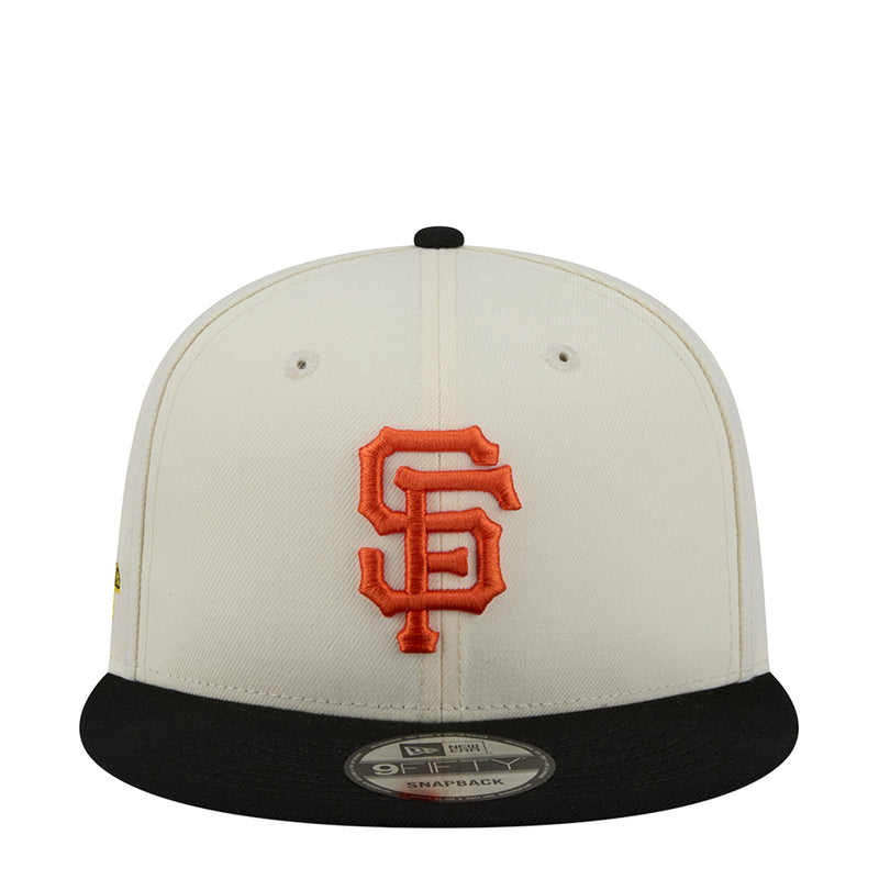 Two-tone snapback cap with orange embroidered S logo on white front, black brim