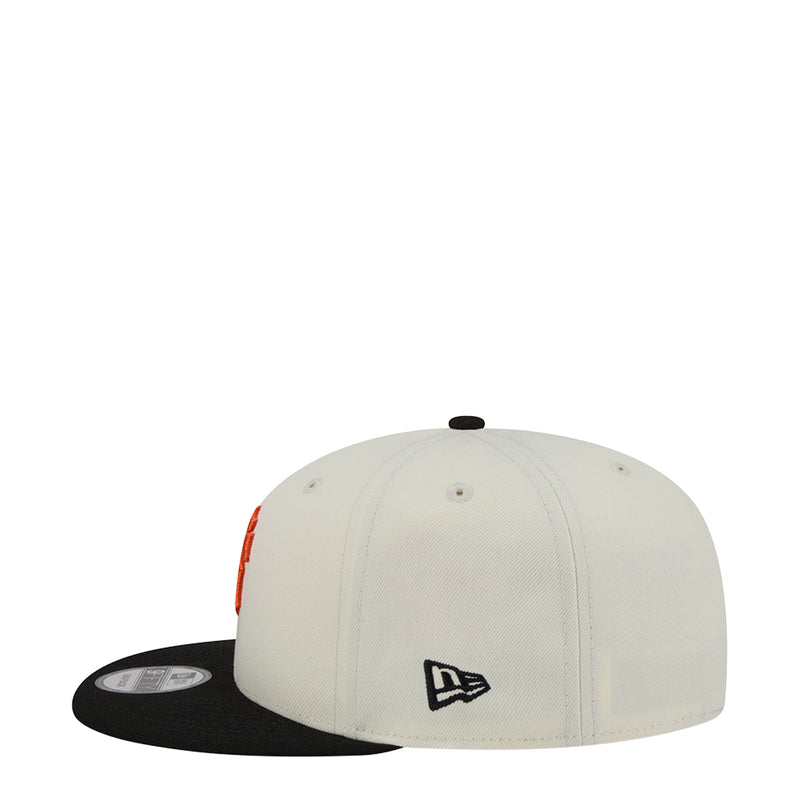 Two-tone snapback cap with New Era logo on white front panel, black side brim
