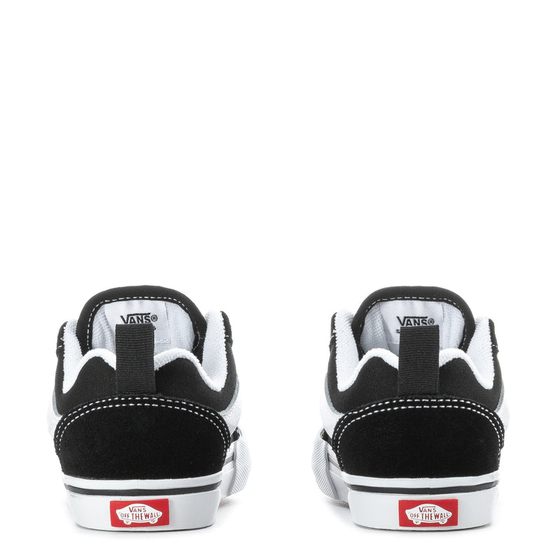 Toddler black sneakers with white heel stripe, lace tab, and Vans logo on back