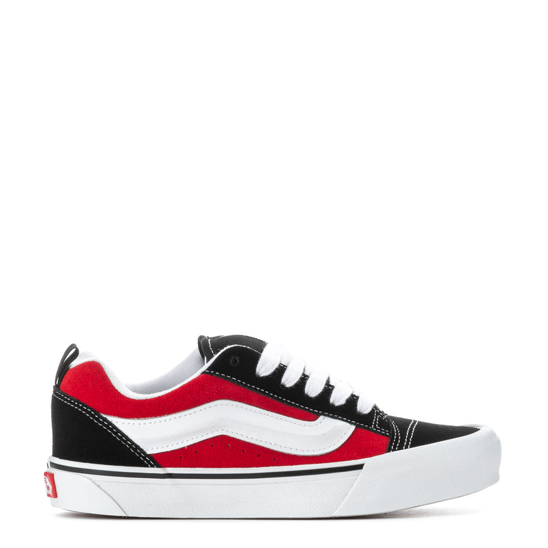 Youth sneakers, black with red and white panels, white laces and rubber sole.