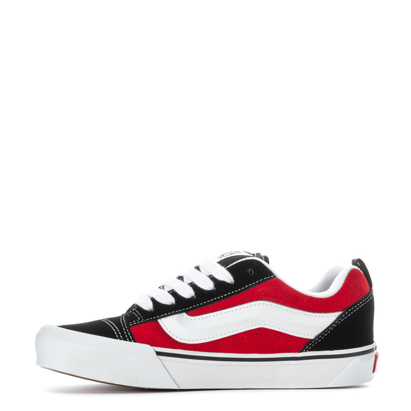 Youth low-top sneakers in black, red, and white with side stripe and white laces.