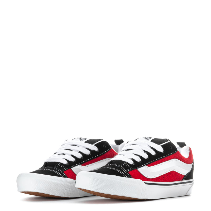 Pair of youth black low-top sneakers with red-and-white stripe and white laces.
