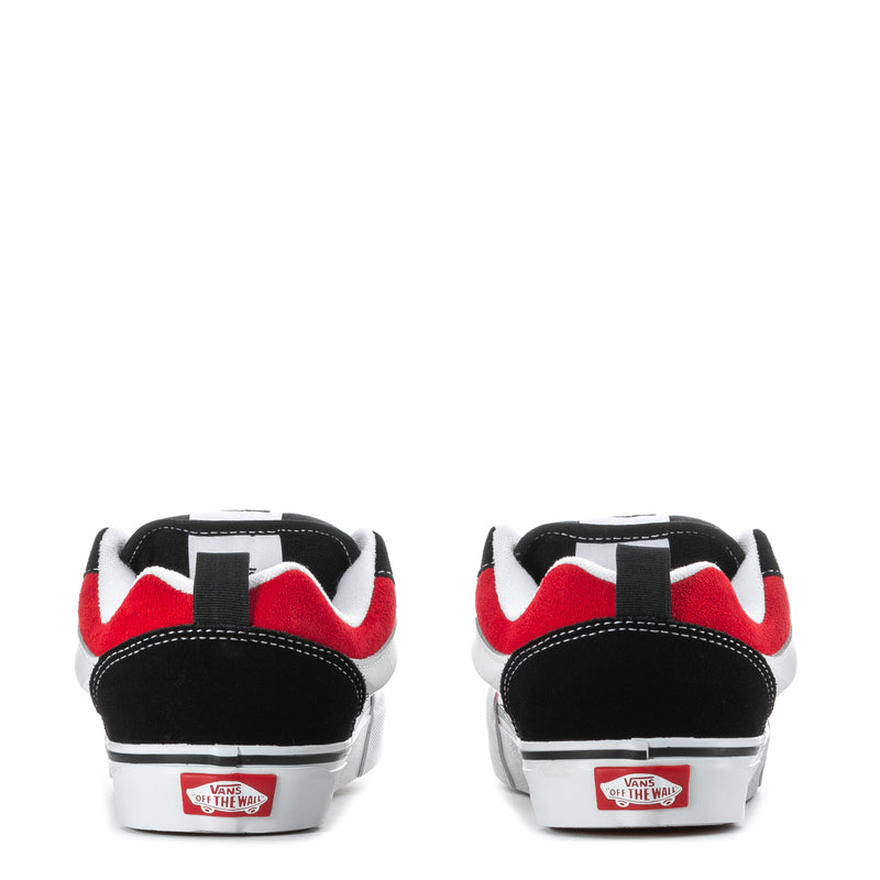 Youth sneakers heel view with VANS tag, black uppers, red accents, white sidewalls.