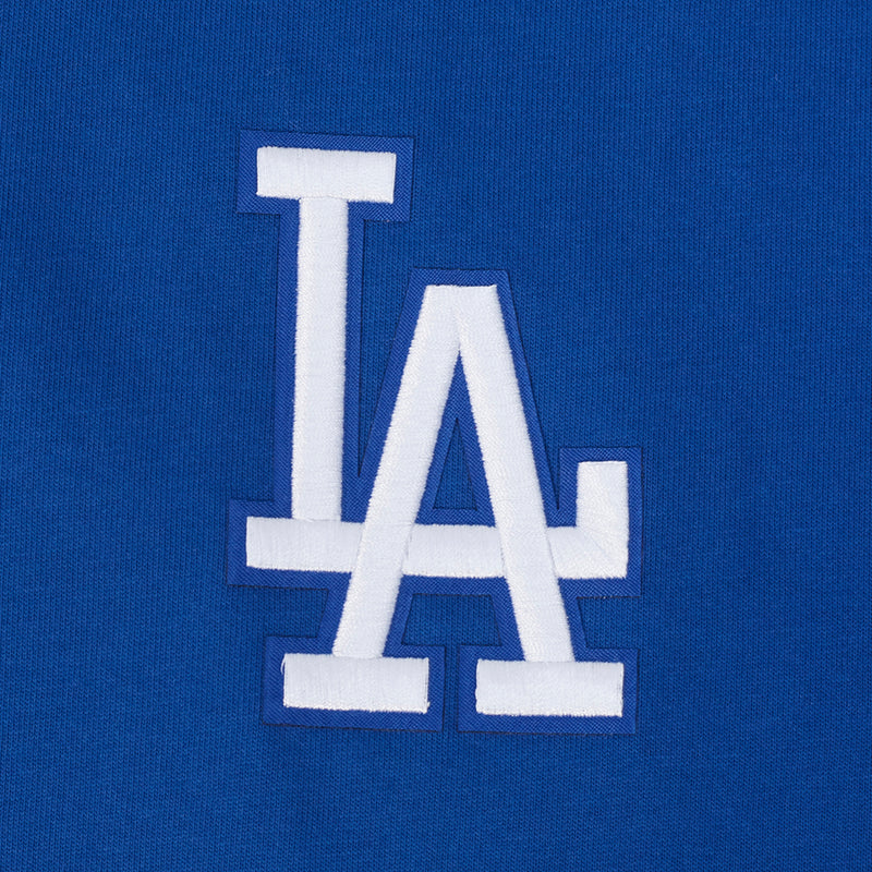 Close-up of blue T-shirt chest with white “LA” logo embroidery