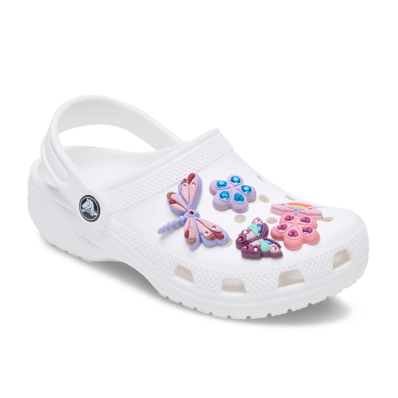 White clogs with colorful Jibbitz charms: paw print, rainbow cloud, butterflies, flower, bug