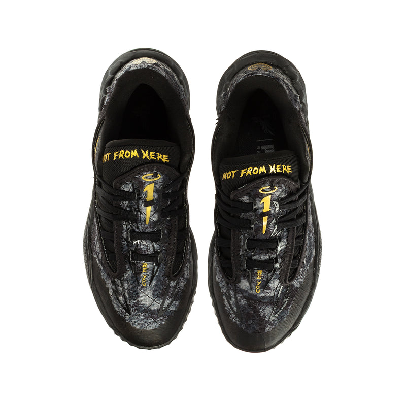 Youth black lace-up sneaker pair, front view, yellow logo print along inner tongue