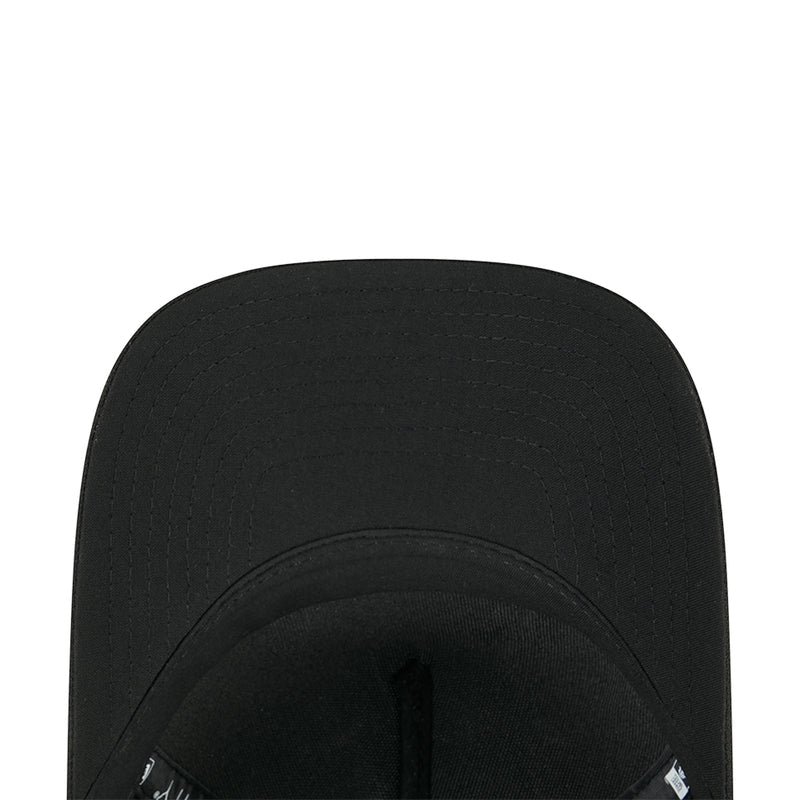 Black baseball cap interior close-up with adjustable strap and small tag