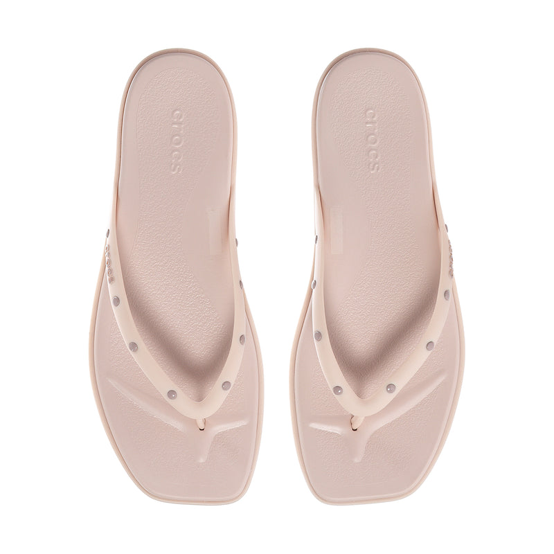 Women's light pink flip-flops with studded thong straps and smooth footbed