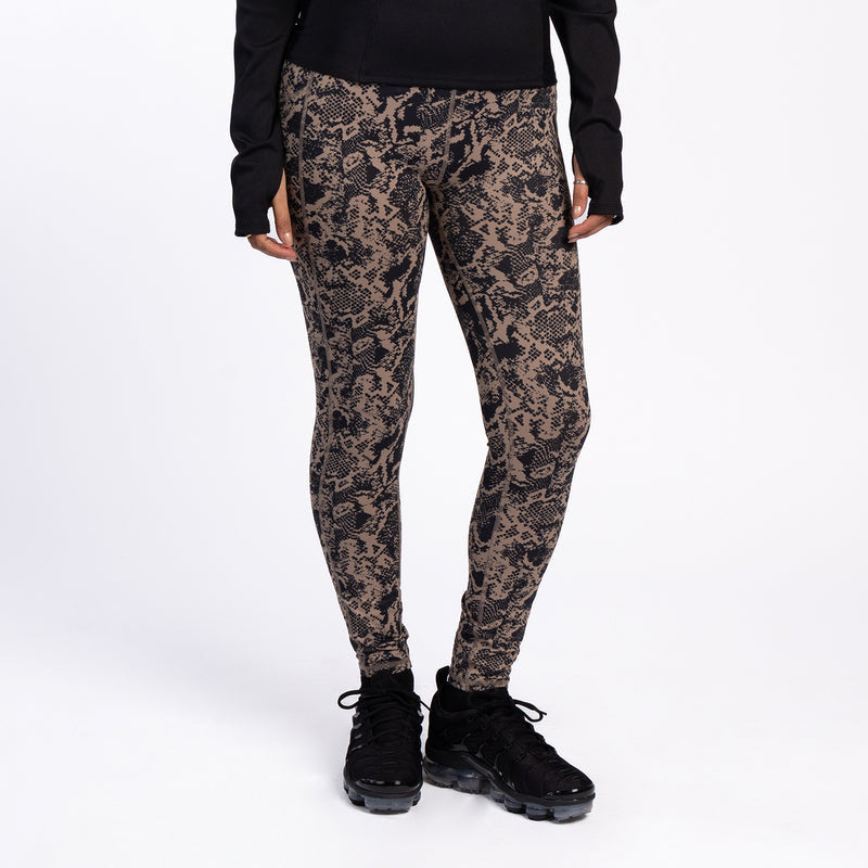 Women's snakeskin-print leggings with pocket, worn with black top and sneakers.