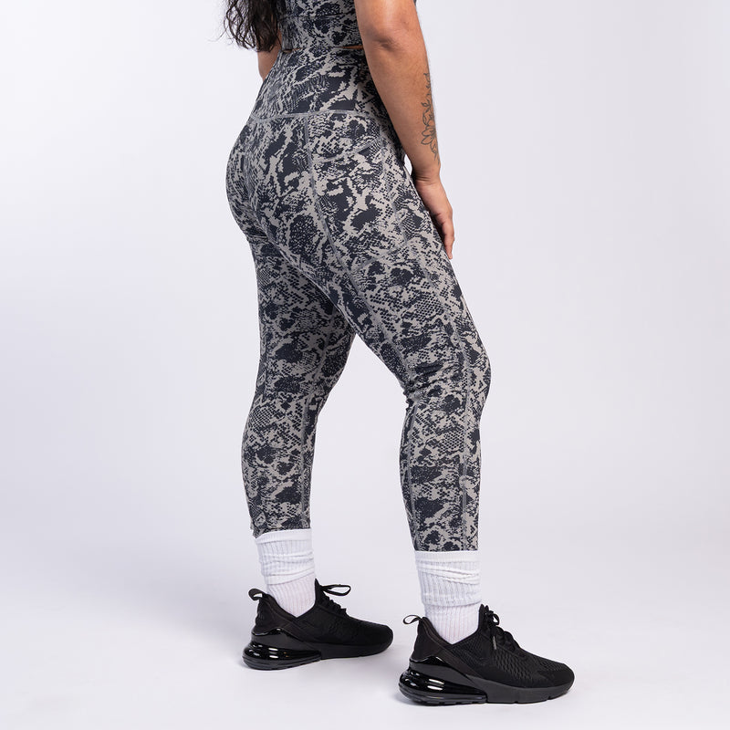 Side view of snake print high-waist leggings in dark gray and black