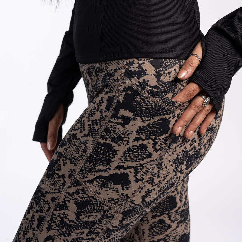 Women's snakeskin-print pocket legging with hand at side pocket, hip detail.