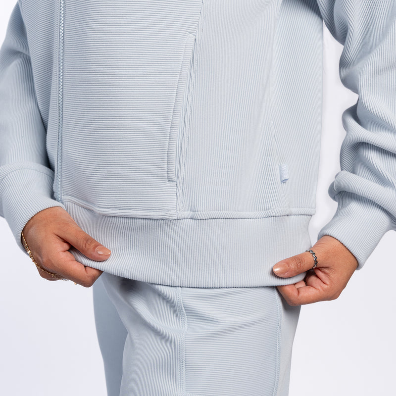Light blue ribbed jacket close-up: full-zip front, ribbed hem and cuffs