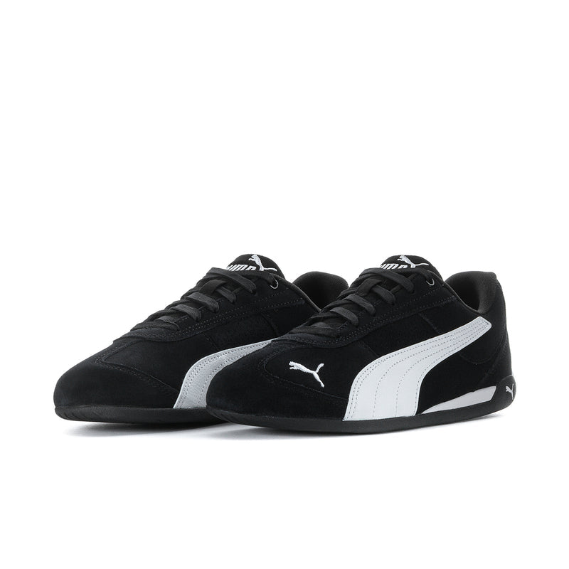 Women's black low-top sneakers with white stripe and PUMA logo, side view