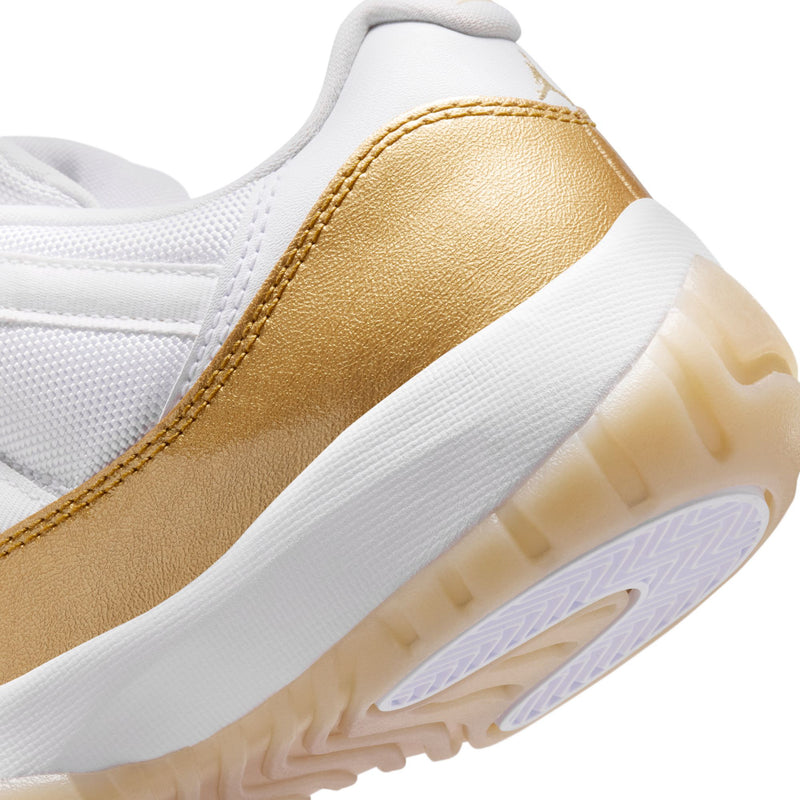 Close-up of gold-and-white sneaker quarter with textured sole and lace area