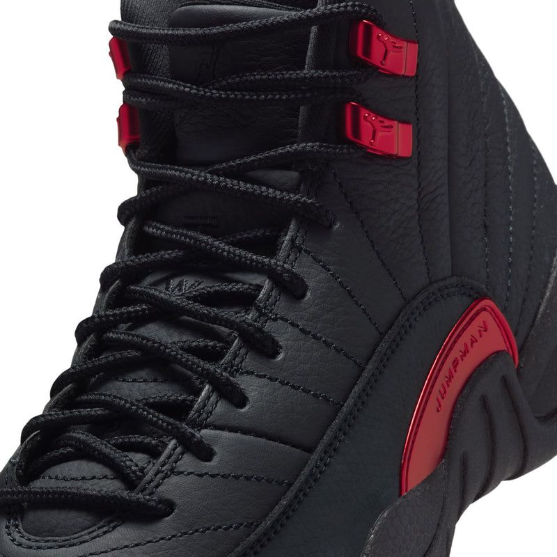 Youth high-top sneaker close-up: black laces with red buckles and stitched overlays