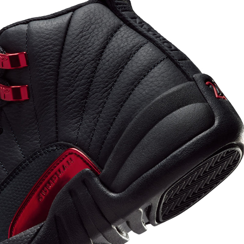 Youth high-top sneaker close-up: black textured panels with red accent and tread