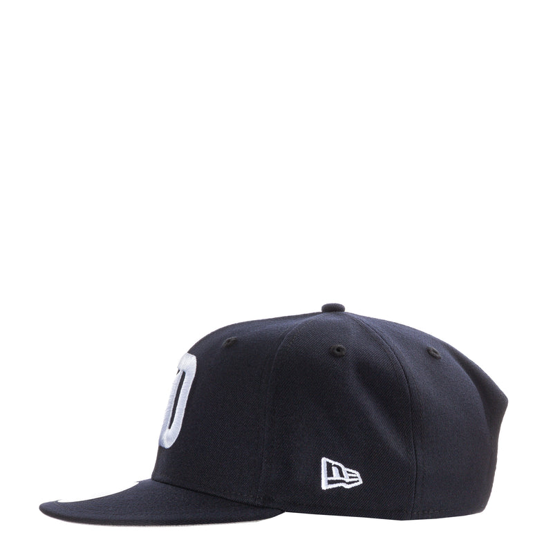Navy baseball cap with white side emblem and New Era logo