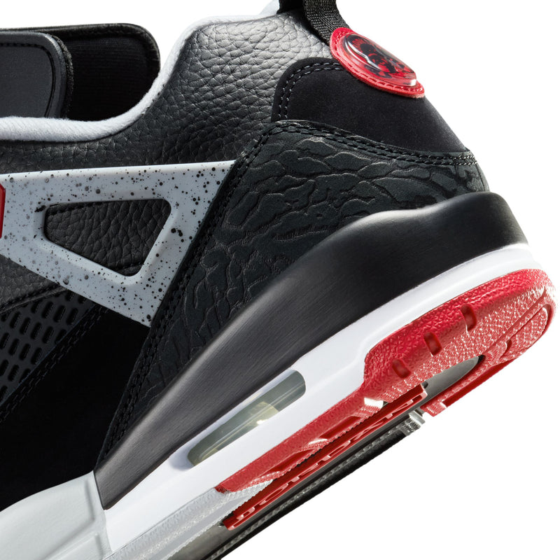 Close-up of men's black low-top sneaker with white air window and red sole detail