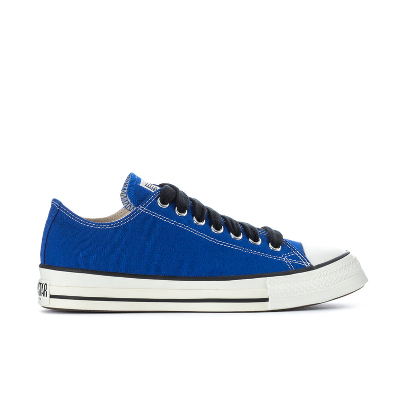 Blue low-top canvas sneakers with black laces and white rubber toe cap and sole