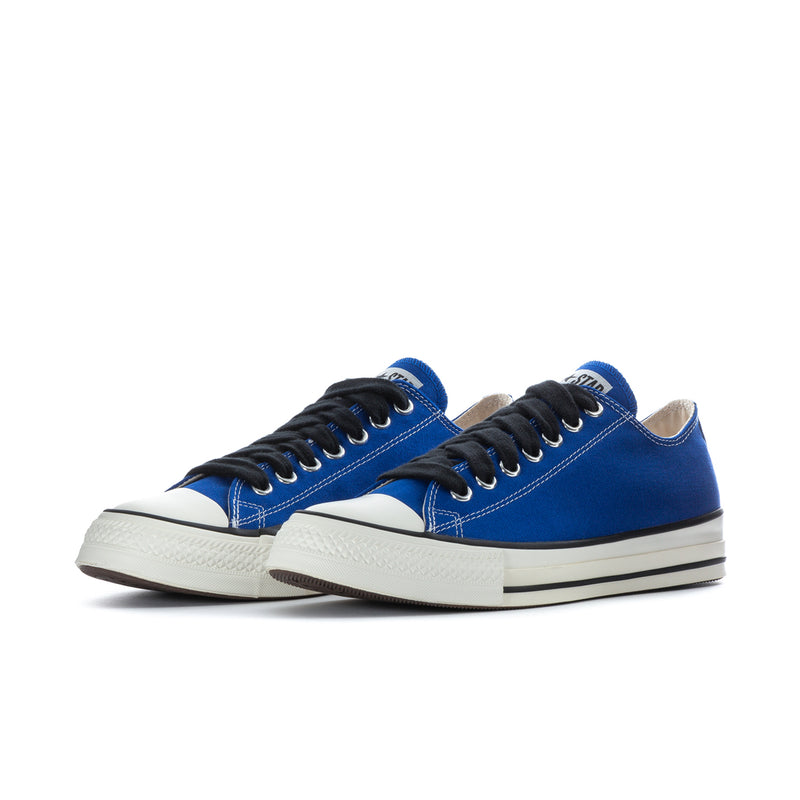 Pair of blue low-top canvas sneakers with black laces and white midsoles