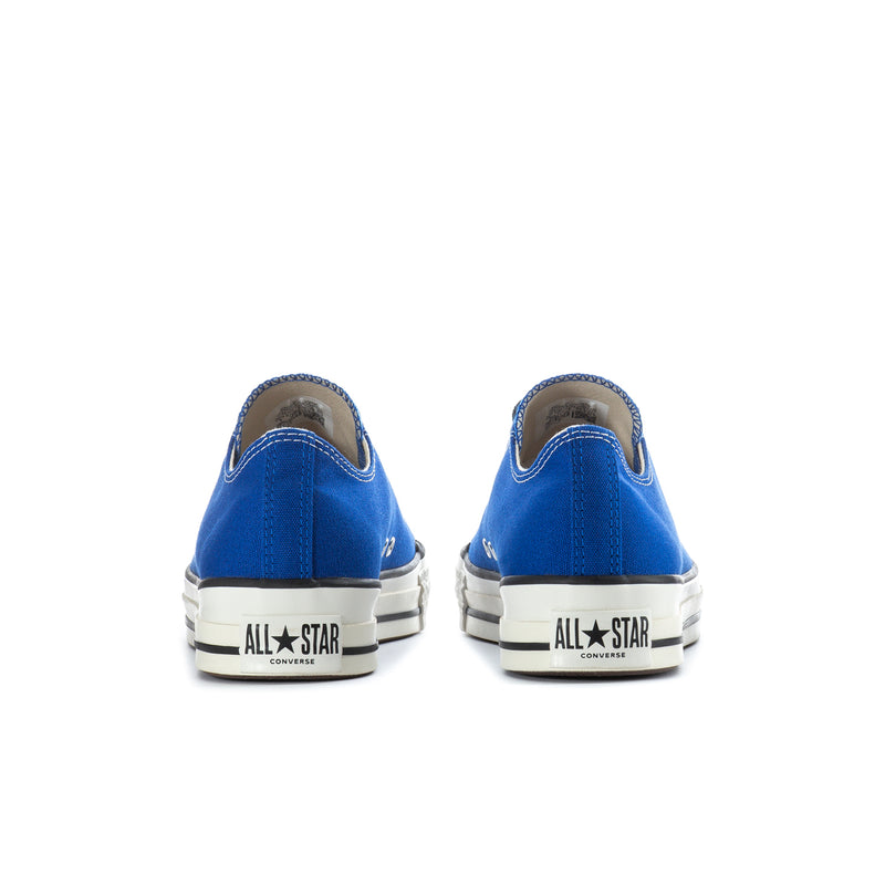 Blue low-top sneakers with heel tab and white “All Star” branding on the back