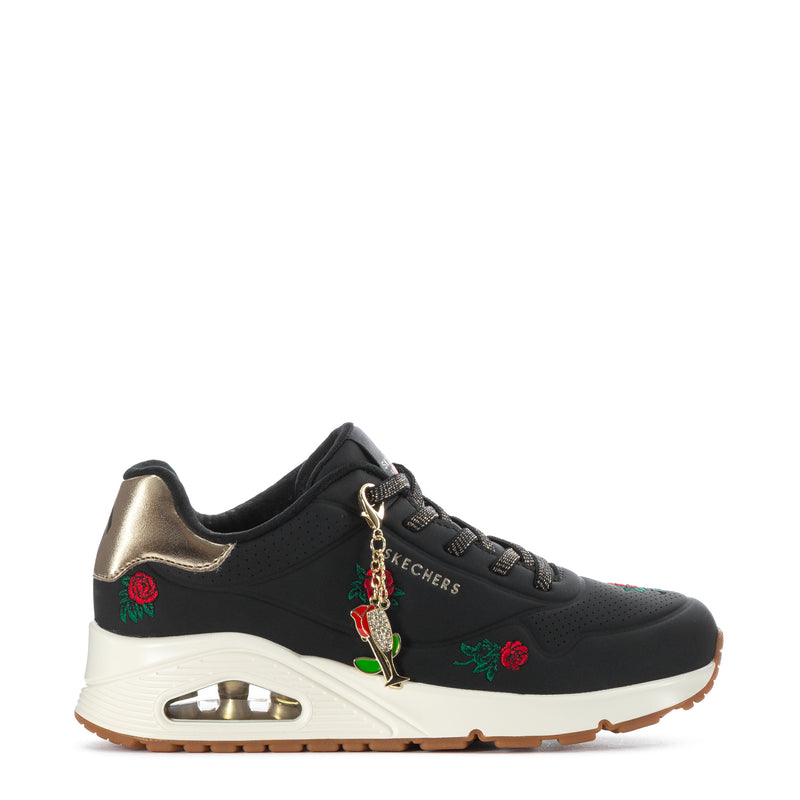 Black lace-up sneaker with white midsole, gold charm, rose and green leaf details