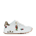 White women's sneaker with gold collar, red rose patches, lace-up, gum rubber sole