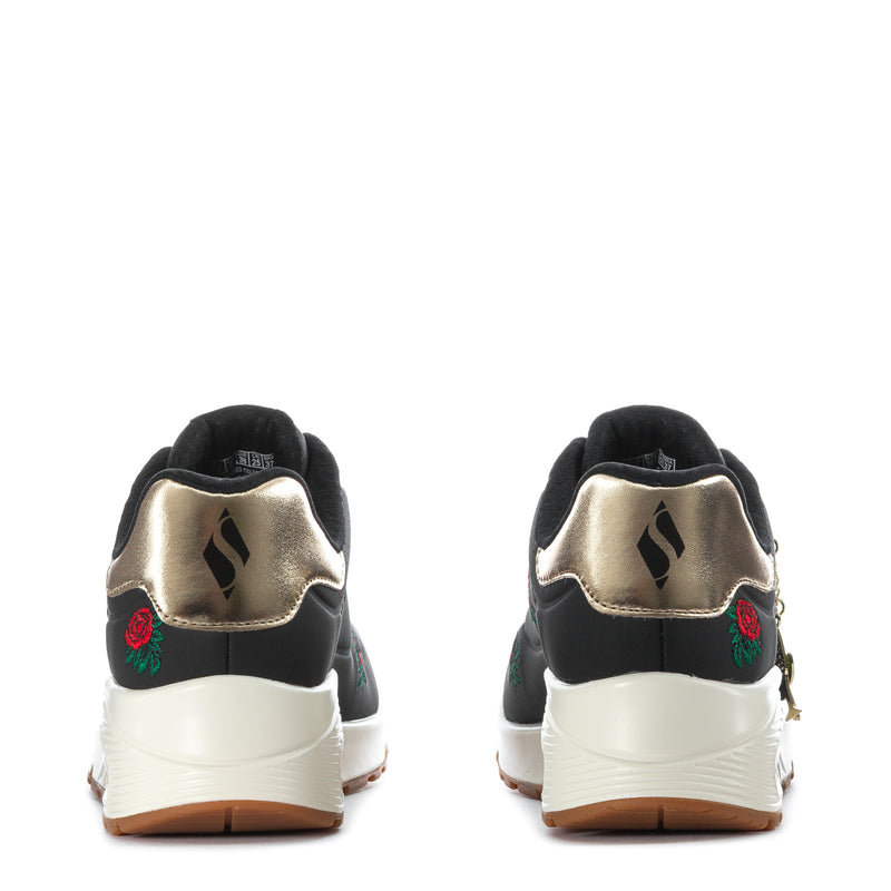 Black low-top sneaker with white sole, metallic heel, rose and green leaf embroidery