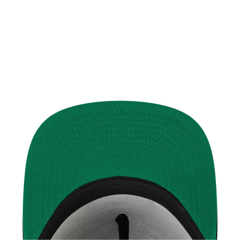 Green baseball cap close-up of crown and black brim edge