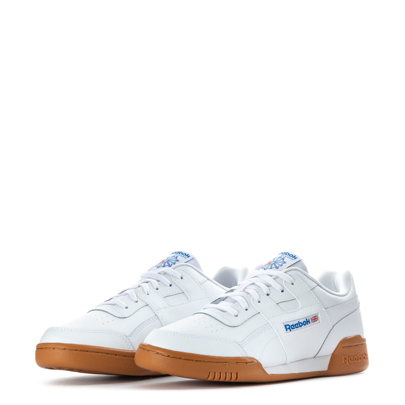 Pair of white youth Reebok lace-up sneakers with gum soles and side logos.
